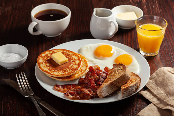 伝統的な全米の朝食の卵パンケーキベーコンとトースト - 写真・画像