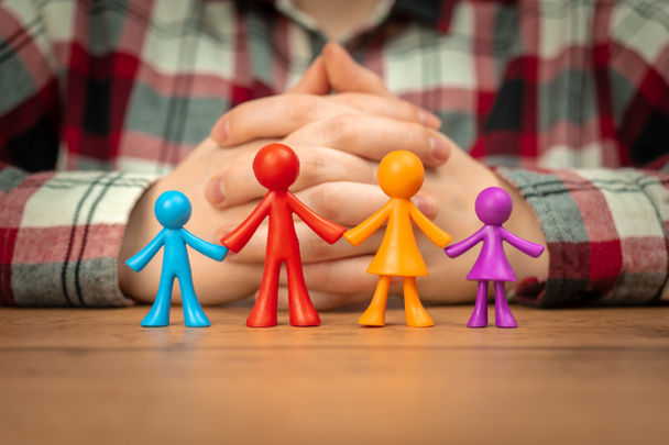 Концепція сімейного страхування з барвистими сімейними статуетками на дерев'яному столі
 - Фото, зображення