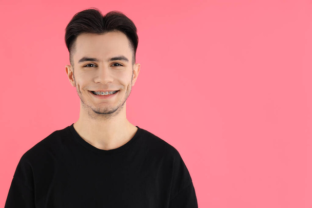 Attractive young man in t-shirt on pink background - Photo, Image