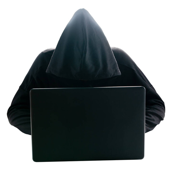 Un hombre desconocido en una capucha frente a un monitor portátil. Hacker en frente de la computadora portátil aislado en blanco. - Foto, imagen