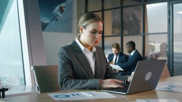 Een jonge vrouw in een pak typt op een laptop. Jonge zakenvrouw op kantoor - Video