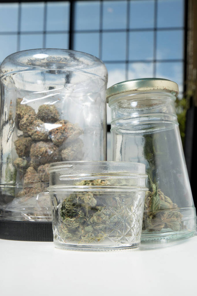 Des bourgeons de cannabis et de marijuana dans des pots en arrière-plan, gros plan - Photo, image