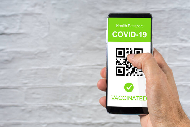 Mão segurando smartphone com saúde vacinada aplicativo de passaporte digital no telefone celular para viajar durante a pandemia covid-19 - Foto, Imagem