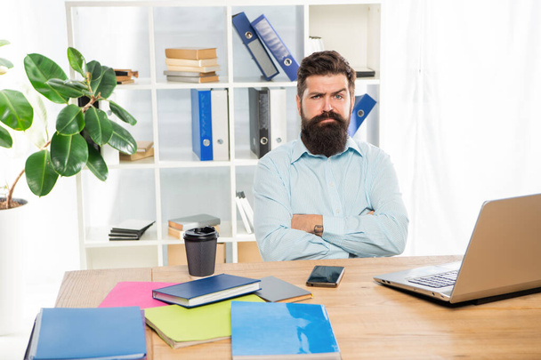 Confident sceptical businessman keeping arms crossed sitting at office desk, confidence - Фото, изображение