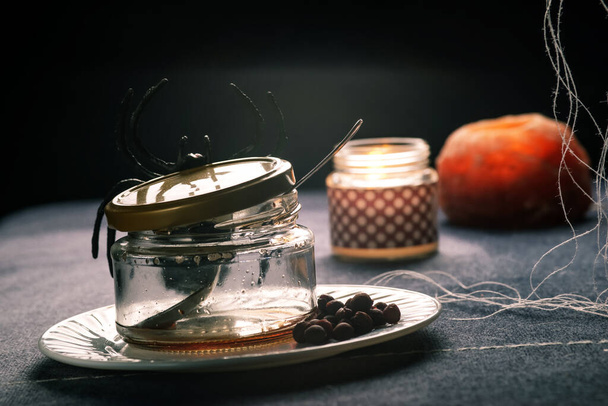 empty jam jar with huge spider and candles - Фото, изображение