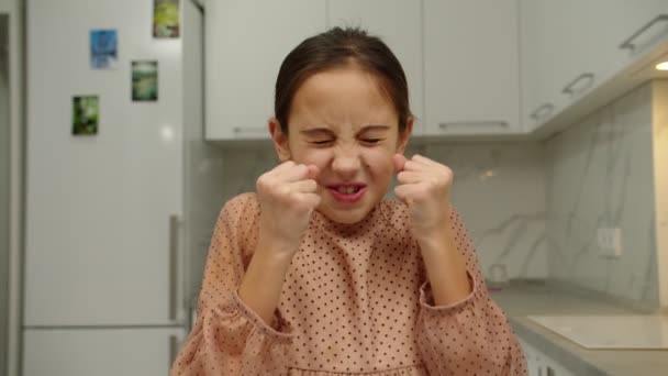 Preteen κορίτσι σφίγγει τις παλάμες σε γροθιές, εκφράζοντας θυμό σε εσωτερικούς χώρους - Πλάνα, βίντεο