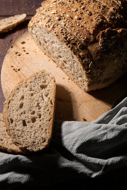 Pane integrale affettato con semi su tavola rustica di legno - Foto, immagini