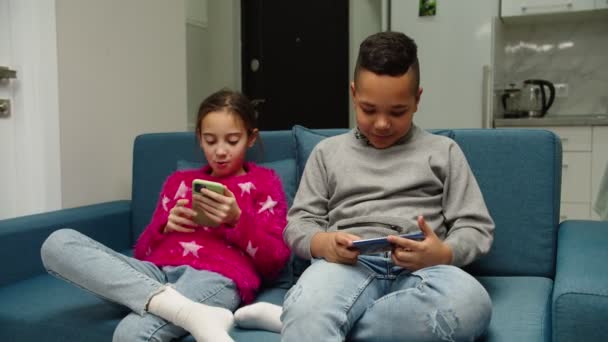 Multiethnische Kinder mit Smartphones, zu Hause auf der Couch. - Filmmaterial, Video