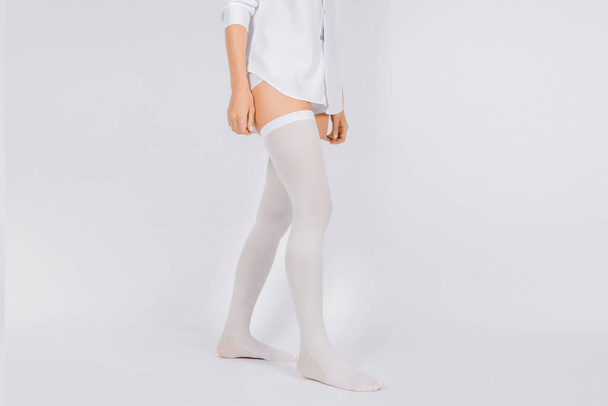 Anti-embolic Compression Hosiery for surgery isolated on white. Medical white stockings, tights for varicose veins and venouse therapy. Thrombo embolic deterrent hose or anti-embolism stockings - Photo, image
