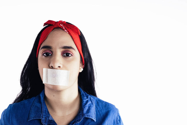 hispanic vrouw met tape op haar mond concept van feminisme, op witte achtergrond. - Foto, afbeelding