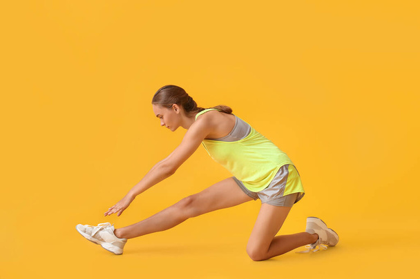 Jovem desportiva exercitando-se no fundo amarelo - Foto, Imagem