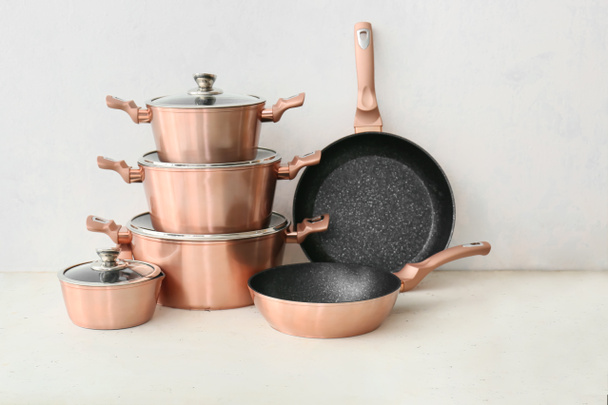 Conjunto de utensílios de cozinha de cobre na mesa contra fundo branco - Foto, Imagem