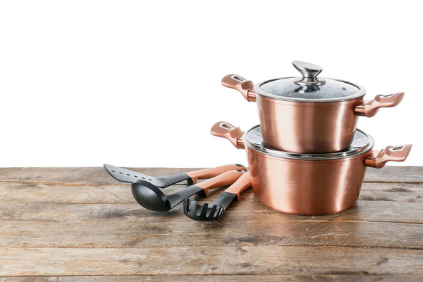 Set of copper kitchen utensils on wooden table against white background - Photo, Image