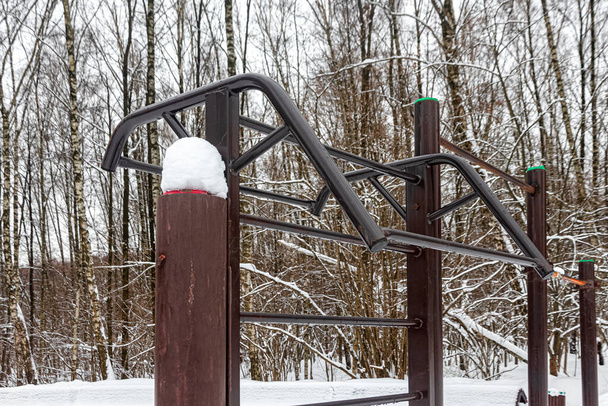 Горизонтальный металлический бар, шведская стена и перекладина для занятий спортом на открытом воздухе в парке - Фото, изображение