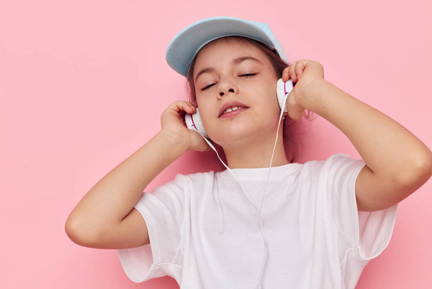 little girl listening to music on headphones isolated background - Fotografie, Obrázek