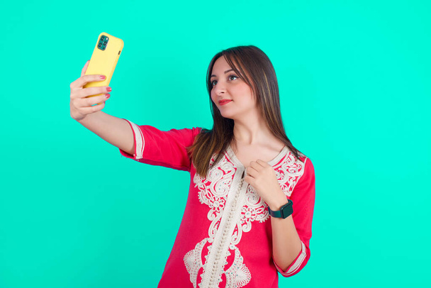 junge schöne kaukasische Frau lächelt und macht ein Selfie bereit, um es in ihren sozialen Medien zu posten. - Foto, Bild