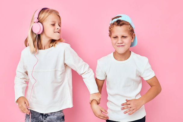 cute boy and girl are playing together pink color background - Foto, Bild