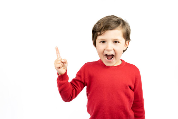 Portrait of cheerful boy pointing to the right - isolated over white background. - 写真・画像