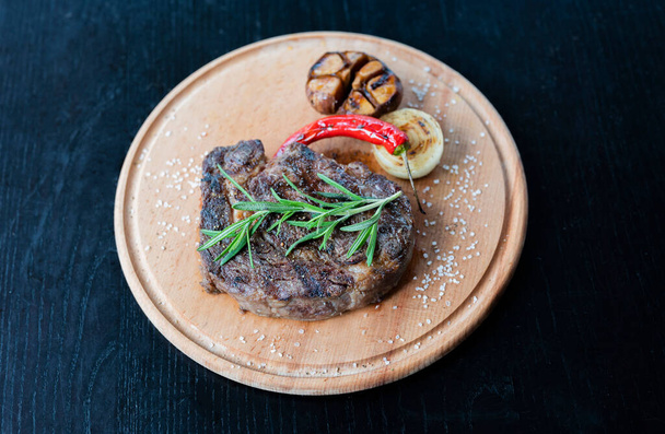 stek ribeye kawałek cielęciny i wołowiny z grilla na drewnianej desce w restauracji - Zdjęcie, obraz