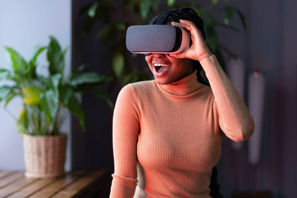 African woman in vr headset feel excited looking at objects of virtual reality in 3d simulation - Foto, Imagem