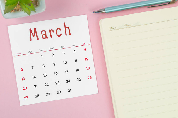 A március 2022 naptár jegyzetfüzet rózsaszín háttér. - Fotó, kép