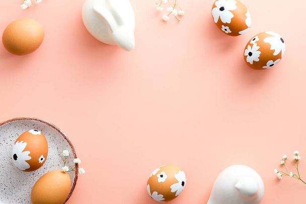 Œufs de Pâques élégants, lapin de Pâques, fleurs sur fond rose pastel. Joyeux modèle de carte de voeux de Pâques. Style minimal. - Photo, image