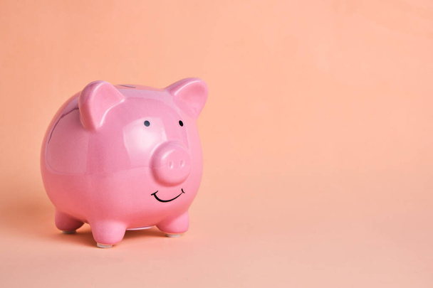 Pink piggy bank on pastel beige background.Concept saving and accumulating money - Foto, Bild