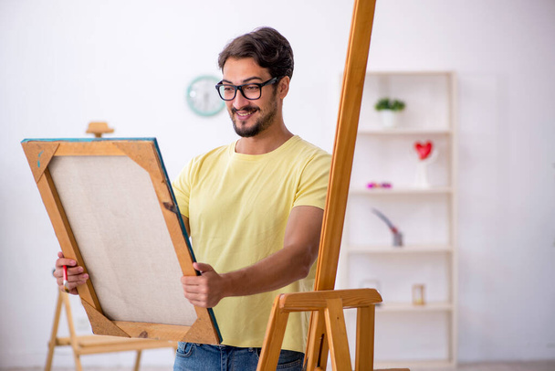 Young man enjoying painting at home - 写真・画像
