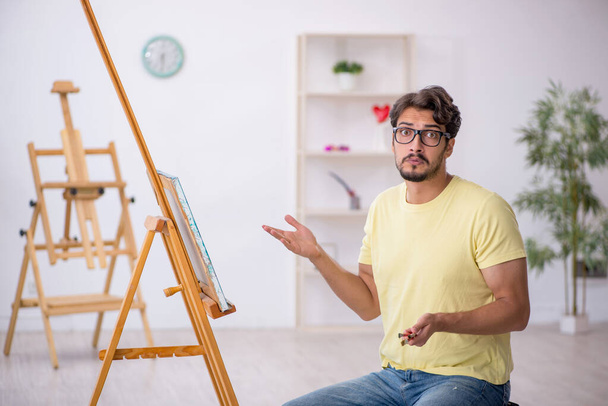 Молодой человек наслаждается живописью дома - Фото, изображение