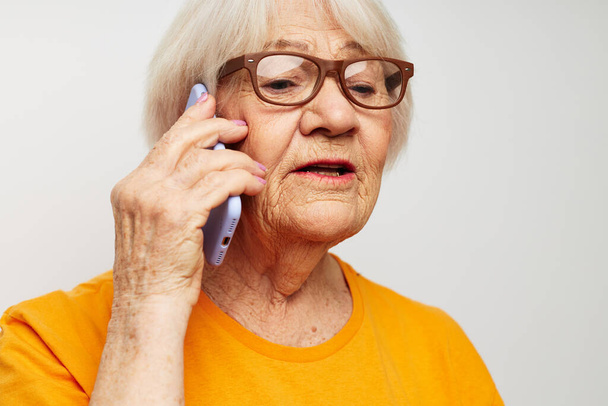 bejaarde vrouw gelukkig levensstijl in gele t-shirts close-up emoties - Foto, afbeelding