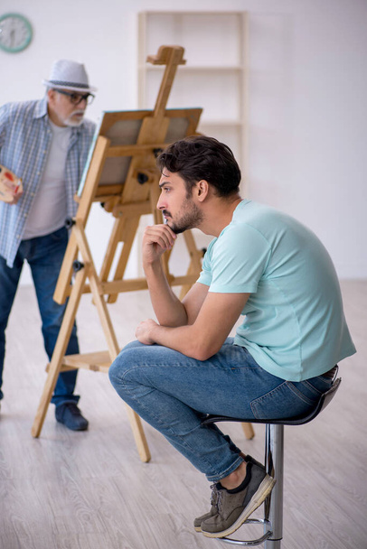 Stary malarz i młody męski model w studio - Zdjęcie, obraz