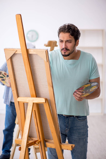 Two male painters enjoying painting at home - Фото, изображение