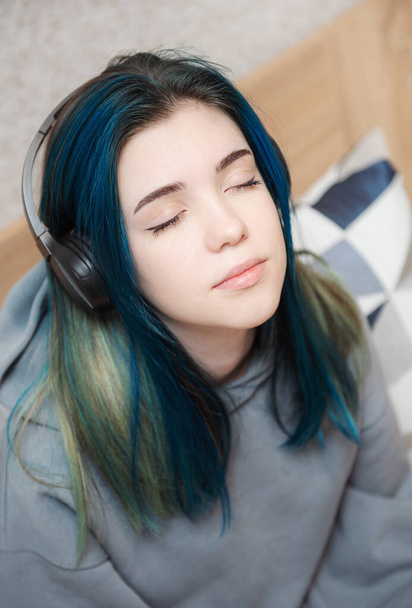 Молода дівчина-підліток з блакитним волоссям і навушниками
  - Фото, зображення