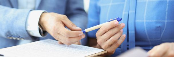 Frau reicht Partner Stift, um Dokument zu unterschreiben - Foto, Bild