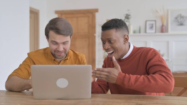 Afrikaner und junger Mann feiern Erfolg am Laptop - Foto, Bild