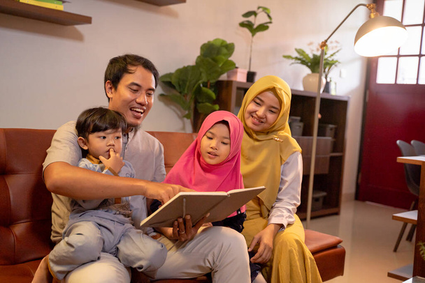 Asian muslim family having fun in livingroom - 写真・画像