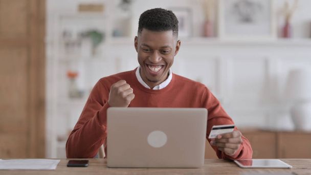 Afrikkalainen mies ostoksia verkossa kannettavalla tietokoneella - Valokuva, kuva