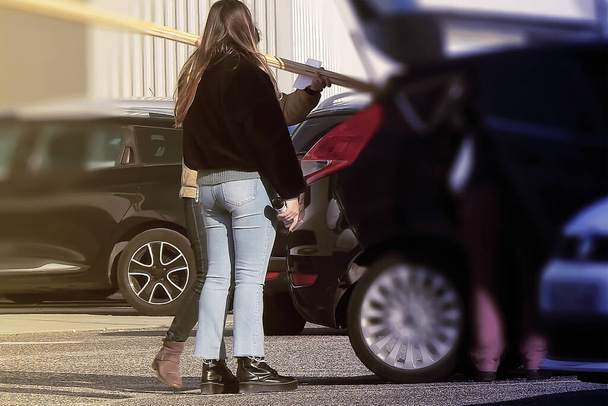 Женщина на парковке идет за покупками в магазин - Фото, изображение