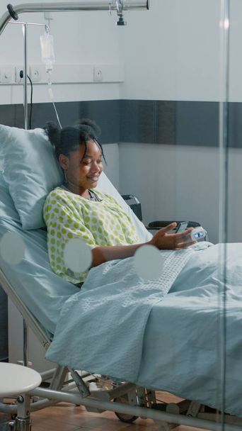 Enfermo paciente sosteniendo el teléfono móvil para hablar en videollamada - Foto, imagen