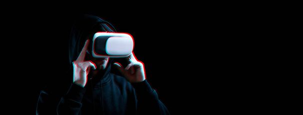 Vr gafas de realidad virtual. Joven desenfocado en auriculares digitales para tecnología de realidad virtual sobre fondo oscuro con efecto glitch. Tecnología increíble, juego en línea, entretenimiento. - Foto, Imagen
