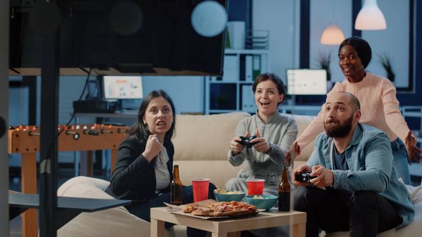 Χαρούμενα άτομα που κερδίζουν βιντεοπαιχνίδια με joysticks - Φωτογραφία, εικόνα