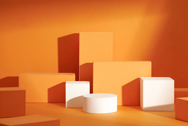 Front view of white and orange podium with and flower in a orange background for advertising , abstract content - Valokuva, kuva