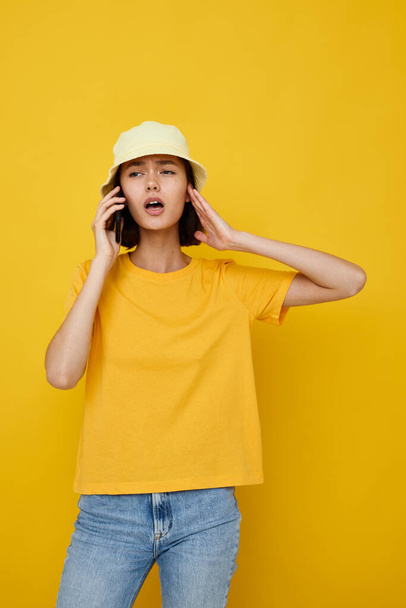 beautiful girl in a yellow hat Youth style casual talking on the phone isolated background - Фото, зображення