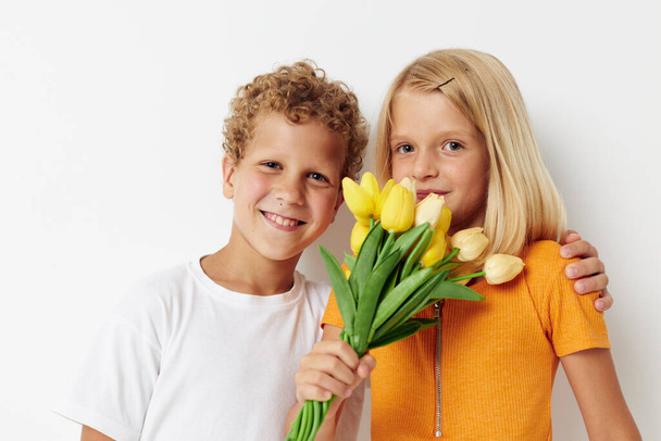 two joyful children fun birthday gift surprise bouquet of flowers isolated background unaltered - Фото, изображение