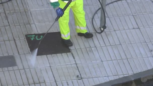 Sweeper cleaning a city sidewalk with high pressure washing machine. Real time video - Footage, Video