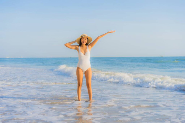 Portret mooie jonge aziatische vrouw gelukkig glimlach rond zee oceaan strand en blauwe hemel voor vrijetijdsbesteding vakantie - Foto, afbeelding