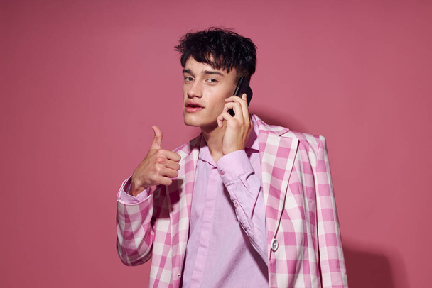 portrait of a young man with a phone in hand pink blazer fashion elegant style Lifestyle unaltered - Photo, Image