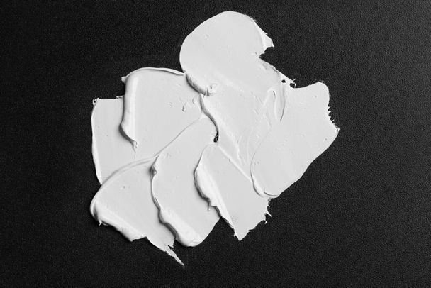 Strokes of white oil paint on black canvas, top view - Foto, Imagem