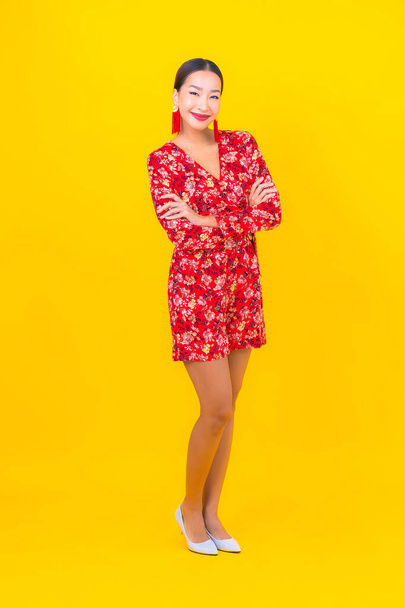 Portrait beautiful young asian woman smile in action in chinese new year concept on color background - 写真・画像