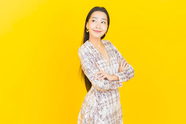 Портрет красивая молодая азиатская женщина улыбка с действием на цветном фоне - Фото, изображение